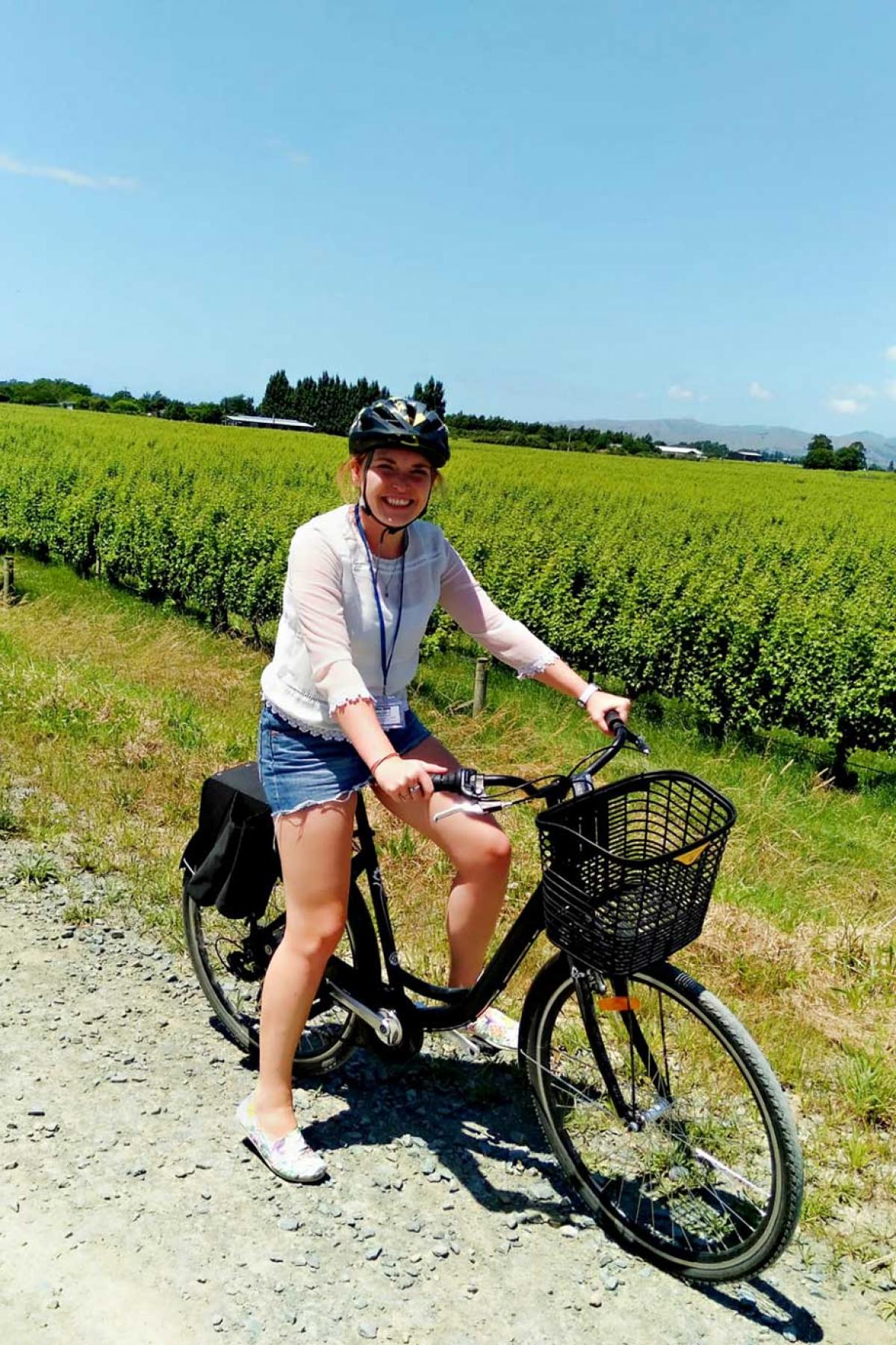 Hannah on a bike amongst vineyards